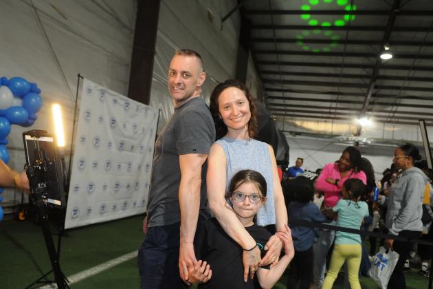 Jennifer Gruet, a teacher at JHS 157 in Queens, is joined by her husband and 9-year-old daughter in the 360-degree photo booth at UFT Family Day on March 29, 2025.