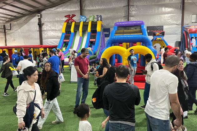 With bounce houses in the background, UFT members and their families pack the indoor sports center for UFT Family Day on March 29, 2025.