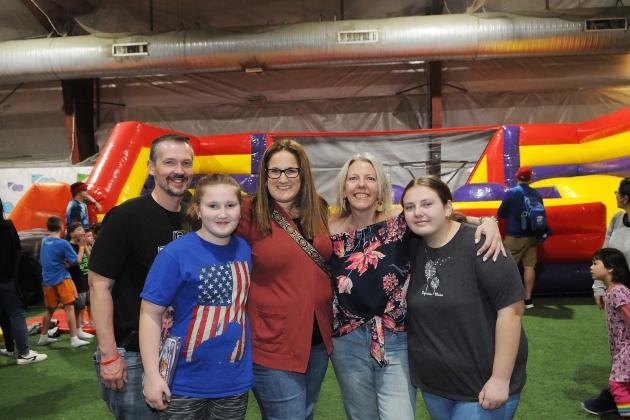 Teachers Kristin Eller (third from left) and Jennifer Watters of PS 229 in Queens take a break from the fun and games to pose for a photo with their families at UFT Family Day on March 29, 2025. .