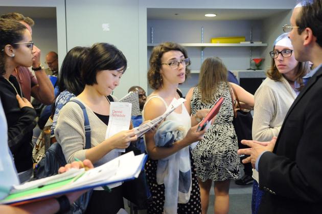 Standing group of UFT members holding UFT Welfare Fund benefits paperwork