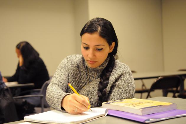 Seated woman filling out UFT Welfare Fund paperwork