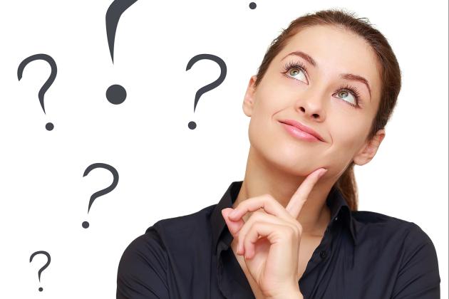 A woman looking up wondering surrounded by question marks