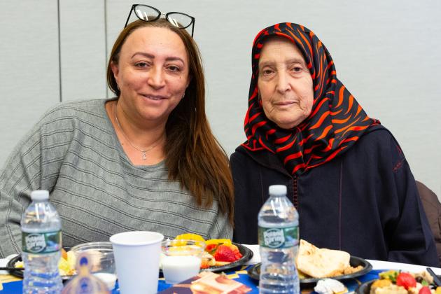 A daughter and mother take a photo while sitting at a table during the UFT Muslim Educators Committee Iftar Dinner on March 7, 2025. 