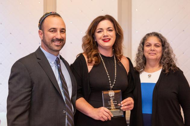 Three UFT members pose for a photo with the woman in the center holding an award she received at the UFT Jewish Heritage Committee's Tikkun Olam Awards Dinner on Dec. 5, 2024