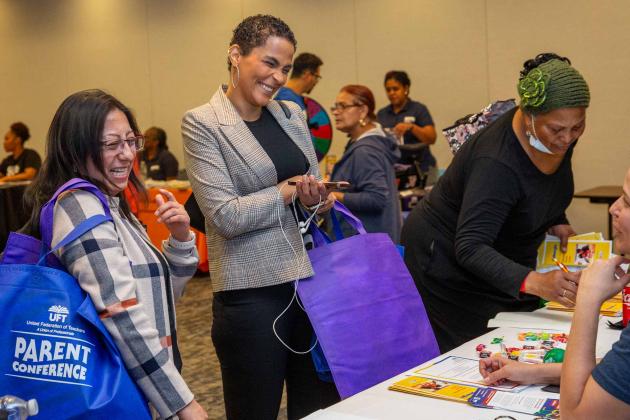 Three women gather at a table for informational supplies