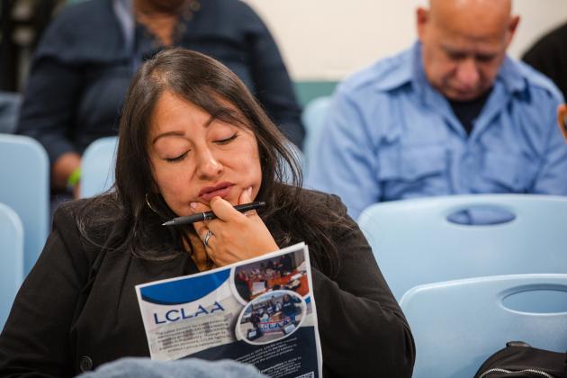 Emily Li, a volunteer Spanish interpreter, studies the program at the 2025 UFT Manhattan Parent Conference.