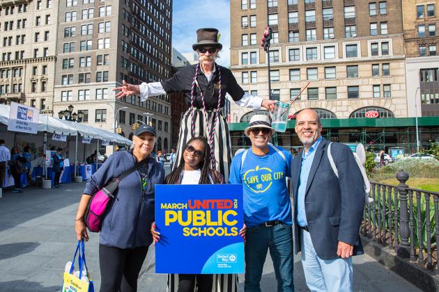 Members pose with man on stilts