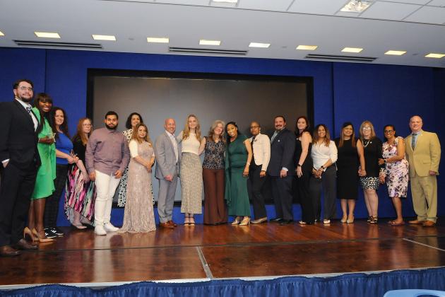 Honorees at the inaugural UFT Middle School Awards take a photo on stage. 
