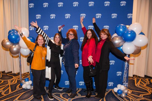 New retirees gather in front of a UFT backdrop for a group photo at the UFT New Retiree Luncheon on Dec. 5, 2024 at the Midtown Hilton