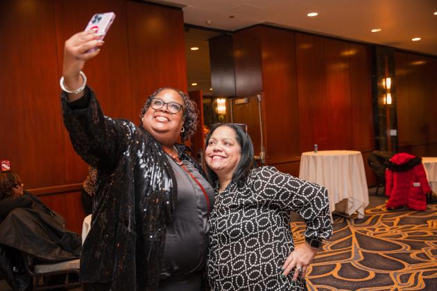 Two new retirees take a selfie together at the UFT New Retiree Luncheon on Dec. 5, 2024. 