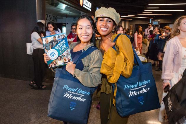 New teachers show off the UFT swag bag and UFT New Member Handbook
