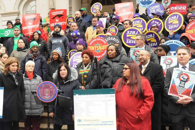 Protesters stand outside City Hall