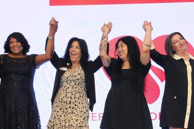 Four nurses on stage celebrate their accomplishments at the 2025 Federation of Nurses/UFT Nurses Recognition Dinner. 