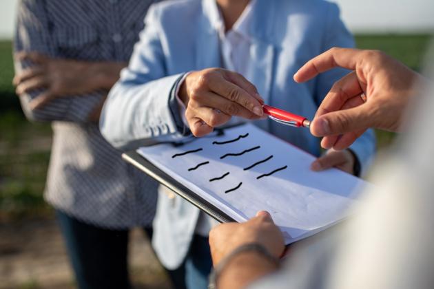 A generic image of someone handing a clipboard to another person to sign a petition. 