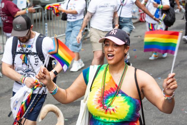 A woman waves rainbow flags at the NYC Pride Parade on June 29, 2025. 