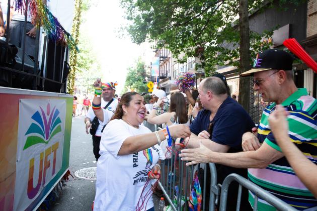 UFT members hand out beads to the crowd as they march alongside the union float at the 2025 NYC Pride March. 