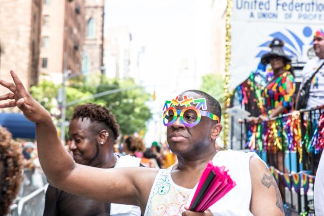 UFT Pride Committee Chair Rashad Brown has fan in hand as he marches along the route in celebration at the 2025 NYC Pride March. 
