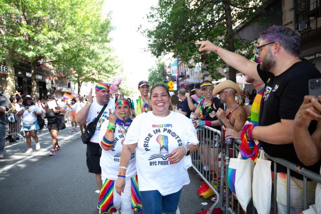 A woman smiles for a photo as she marches alongside the UFT at the 2025 NYC Pride March. 