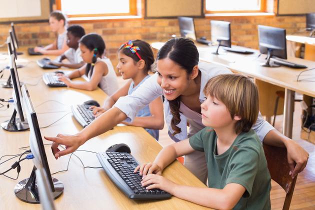 Teacher helps student on computer