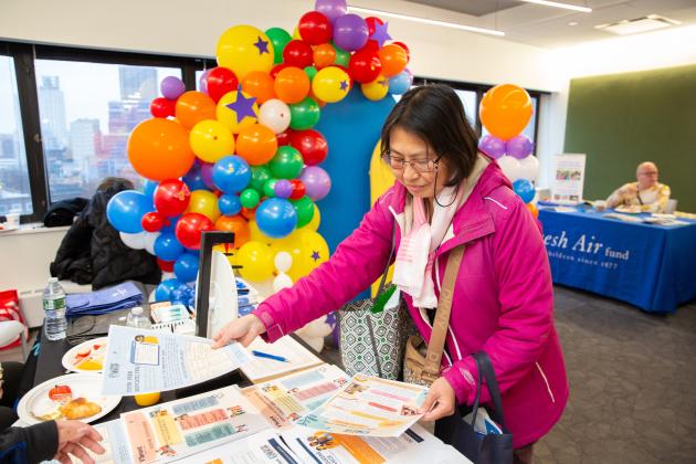 Tiffany Pong, the parent  of a LaGuardia HS student, peruses tables at the resource fair.