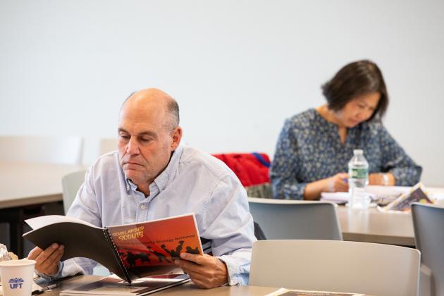 A parent in attendance reads about scholarships during a workshop at the UFT Queens Power Summit on Nov. 23, 2024. 