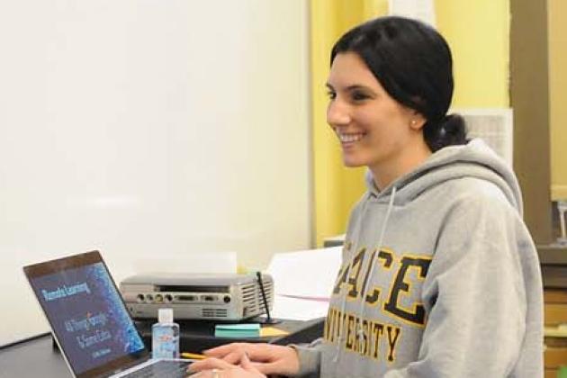 Teacher standing in front of computer in classroom