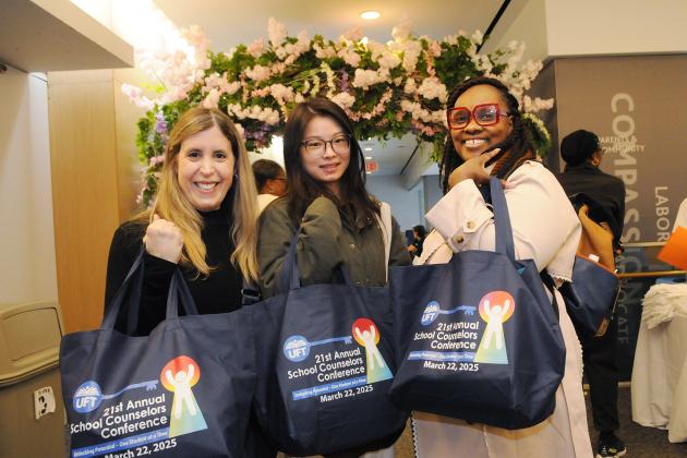 School counselors in attendance at the 2025 School Counselors Conference show off their tote bags. 
