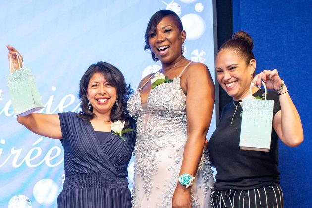 Queens honorees display their congratulatory gift bags proudly as they flank Chapter Leader Sheryl Pender at the UFT School Secretary Awards Soiree on June 6, 2025. 