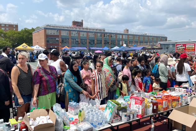Staten Island families check out a giveaway table of food and supplies at the 5th annual Staten Island Back-to-School BBQ.