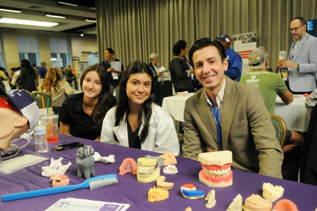 Tottenville High School students and their teacher take a photo at their exhibit hall table during the 2025 UFT Spring Education Conference. 