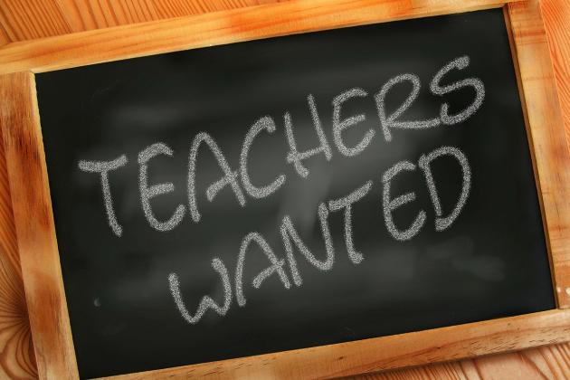 A chalkboard with the writing "teachers wanted" displayed 