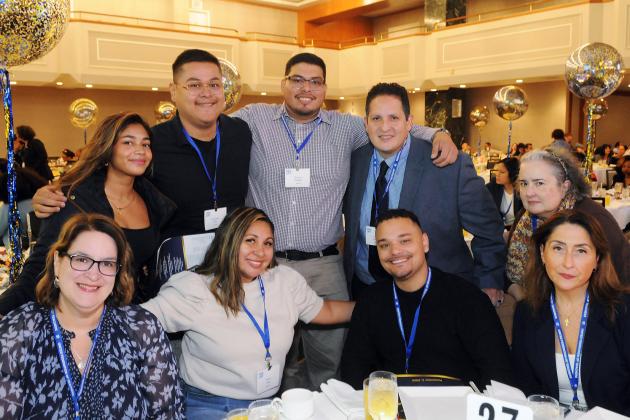 Members from two schools in Queens take a group photo at a table before the start of Teacher Union Day on November 2, 2025. 