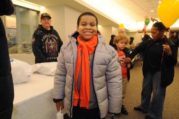 A student shows off a coat he received at the annual UFT Middle Schools Thanksgiving Luncheon