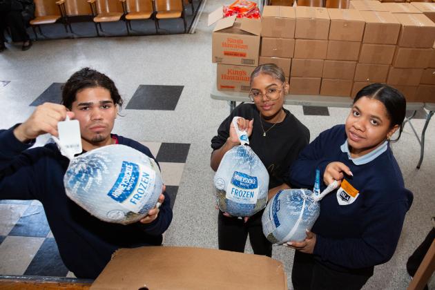 A delay in SNAP benefits and the promise of meat -- chickens and whole turkeys (held by ISLA student volunteers) -- fuel the early arrival of needy families.