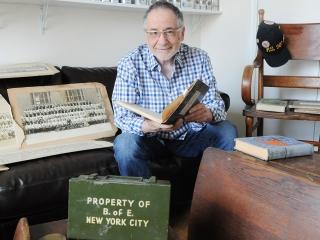 Marty Raskin sits among his treasures, including a Board of Education first-aid 