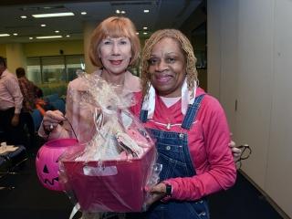 Director of Retiree Programs Gerri Herskowitz (left) presents the prize to raffl