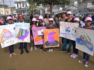 Students hold their class posters.