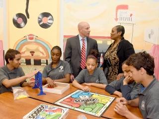 Students play board games on round tables in the cafeteria at MS 129 in the Bron