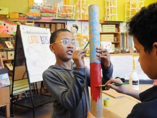 Students work together to paint a prop instrument.