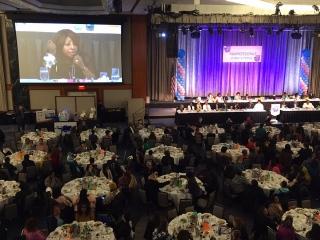 The crowd watches keynote speaker Velma Hill on the big screen.