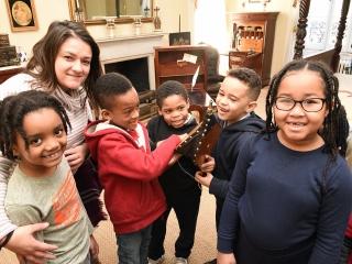 Berisha and students examine the bellows that was necessary to keep the fires bu