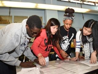 Students at Emma Lazarus HS on the Lower East Side attempt to arrange strips of paper with single words or sentences into a coherent paragraph.