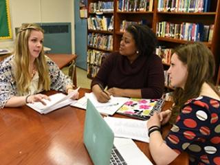 Getting together for a debriefing session following a regular Wednesday meeting with staff are (from left) master teacher Rebecca Schropfer and model teachers Cassandra Baptiste and Michelle Fargnoli.