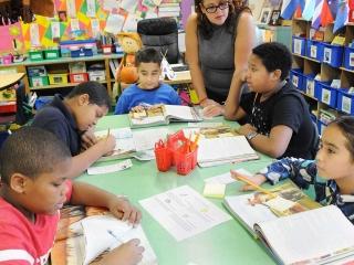 Paraprofessional Maria Rodriguez works with a group of readers. Reciprocal teach