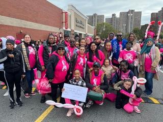 A large group of members wearing pink pose for a photo at a breast cancer awareness walk