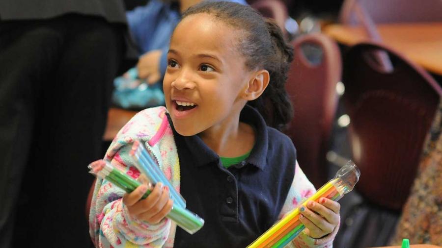 A student’s face lights up as she receives her new supplies.