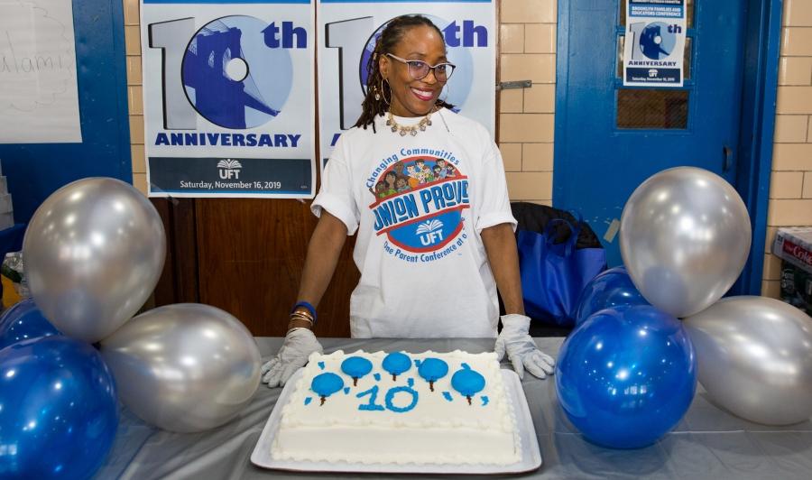 Karen Chambers, a parent volunteer for the Brooklyn conference, displays a 10th-anniversary cake.