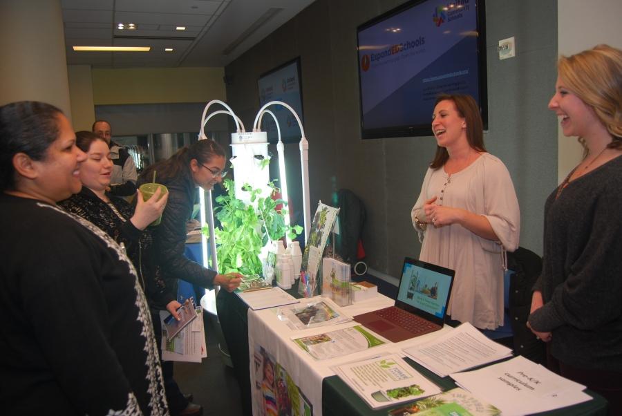 Members share a laugh at the information table at the UCS partner expo. 
