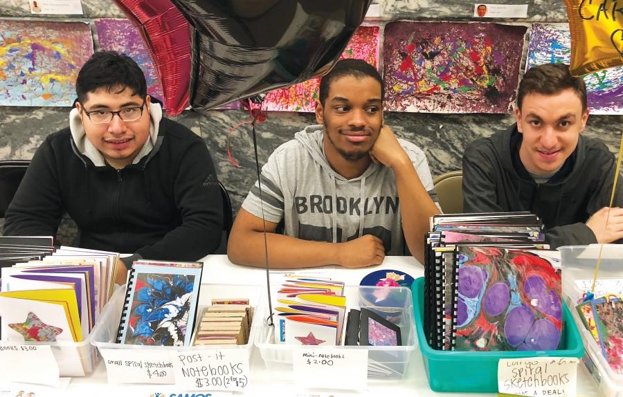 Three students selling artwork