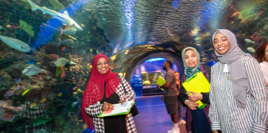 Three women visiting an aquarium.